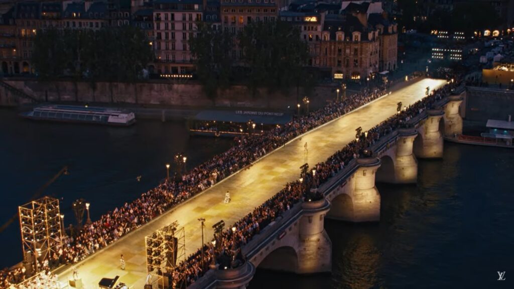 Um desfile de moda e de celebridades sobre a Pont Neuf em Paris. A