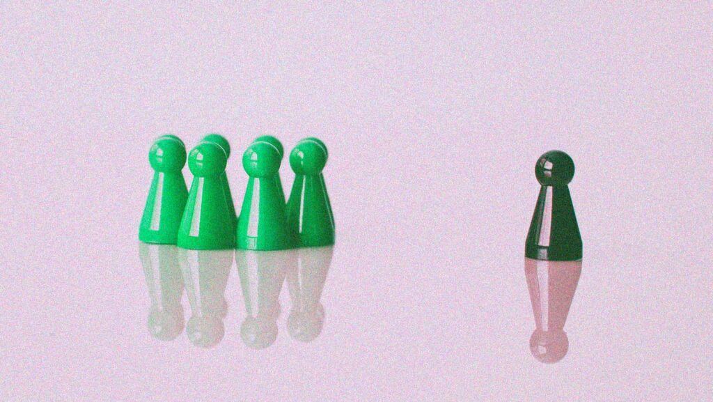 pino preto destacado entre grupo de pinos verdes em alusão ao conceito de liderança