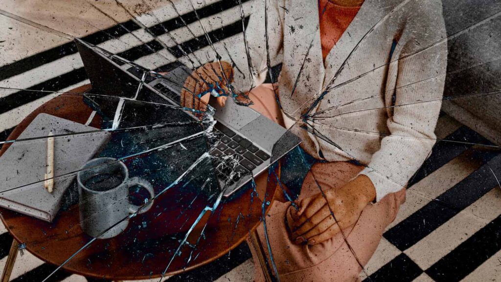 funcionária em trabalho remoto vista através de vidro quebrado