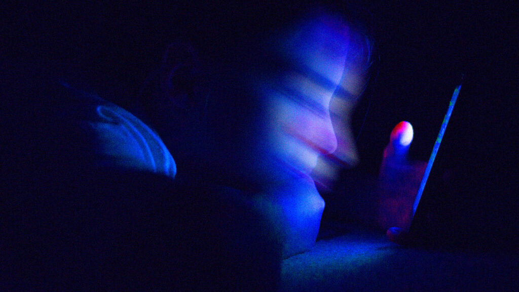 imagem borrada de rosto de criança olhando para o celular