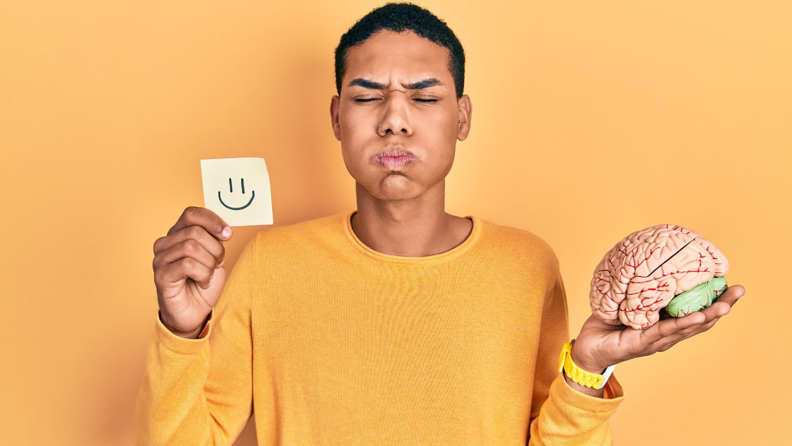 Homem negro segurando um cerébro e uma folha com rosto feliz