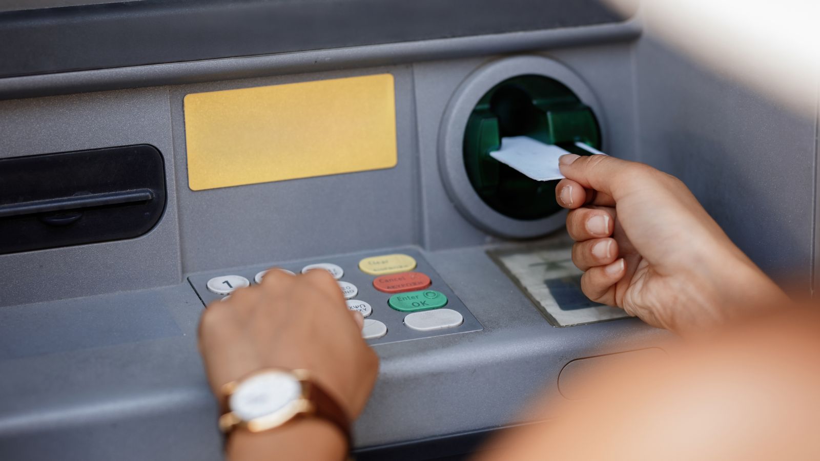 Mulher sacando dinheiro do caixa eletrônico