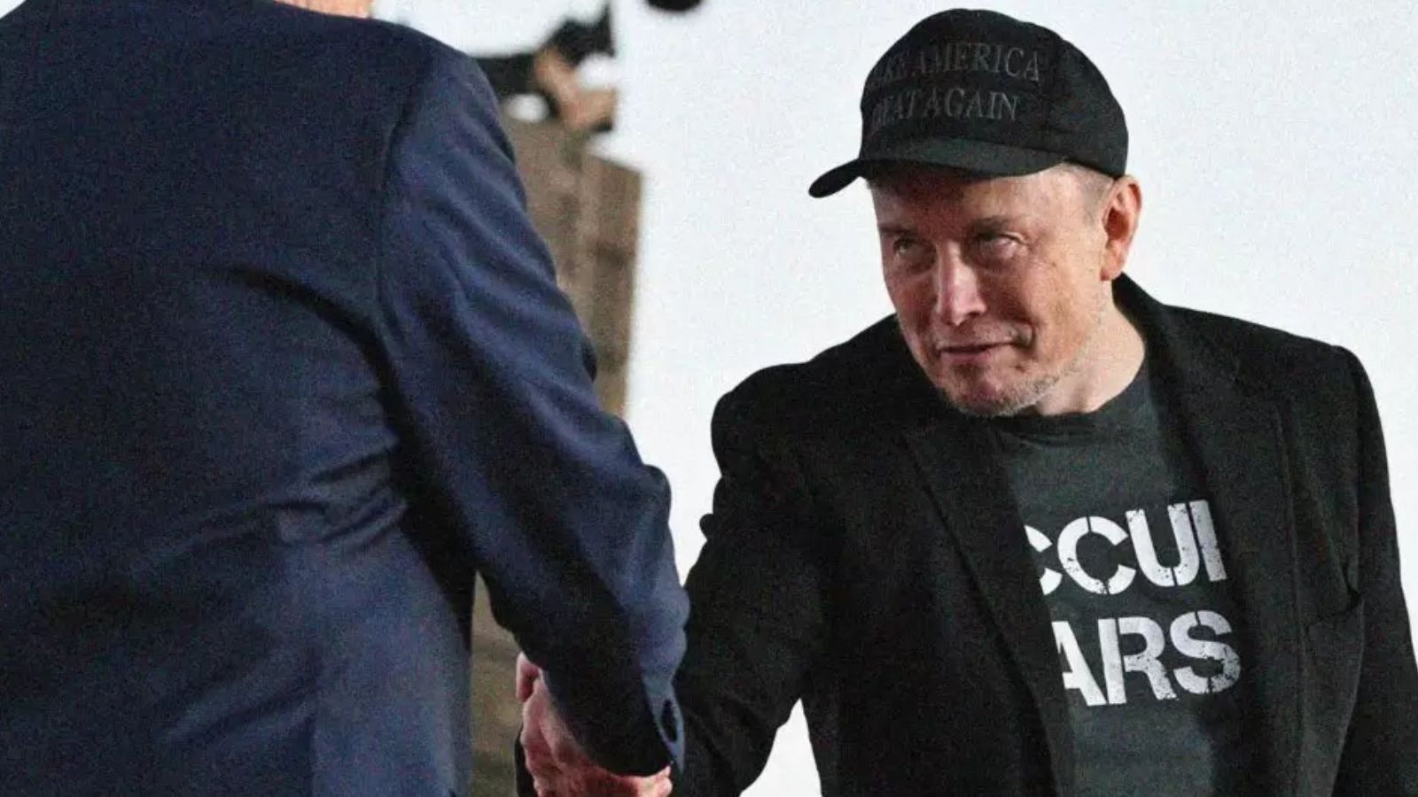 Elon Musk apertando mão de outra pessoa