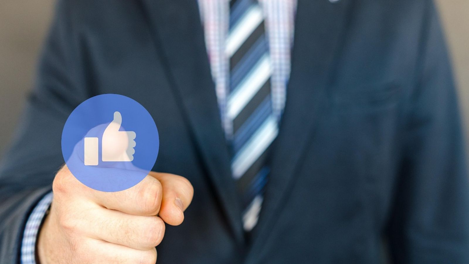 Mão com símbolo de like do facebook