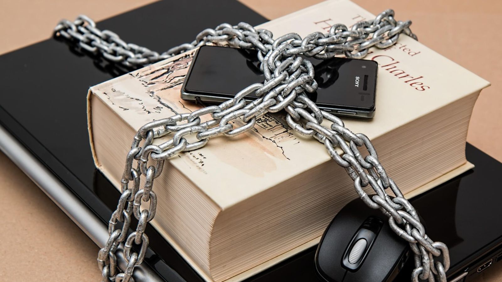Celular acorrentado em cima de livro