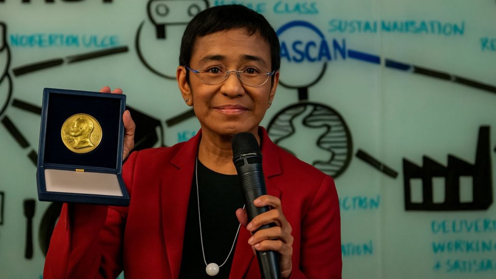 Vencedora do Nobel segurando prêmio