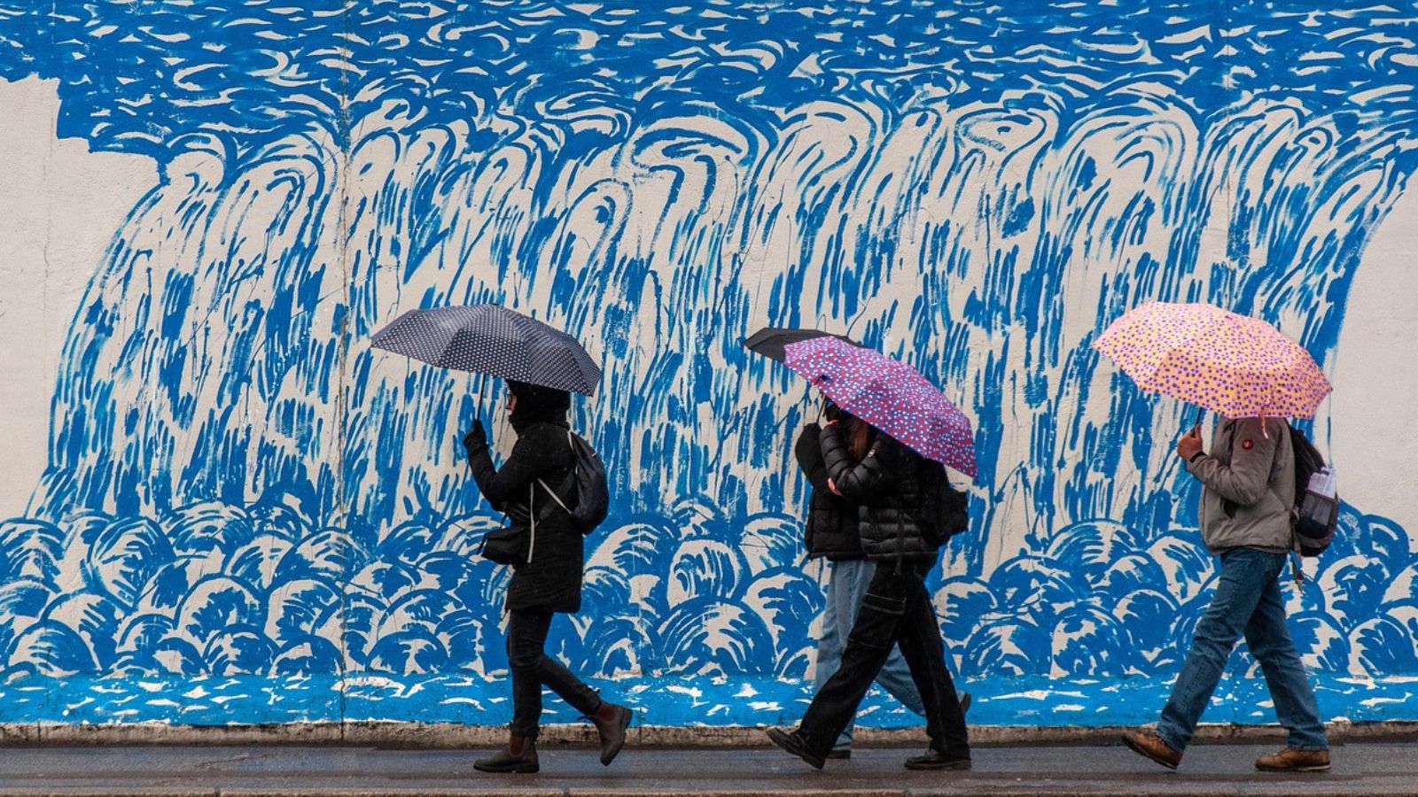 Pessoas indo trabalhar com guarda-chuva