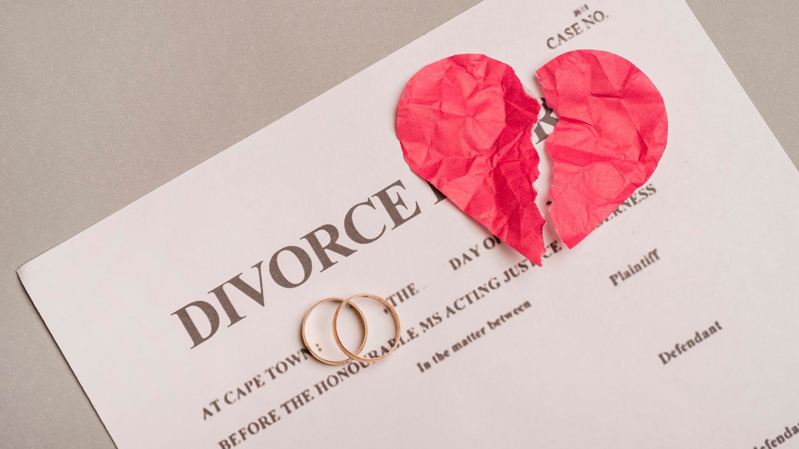 Papel de divórcio com aliança em cima e coração partido