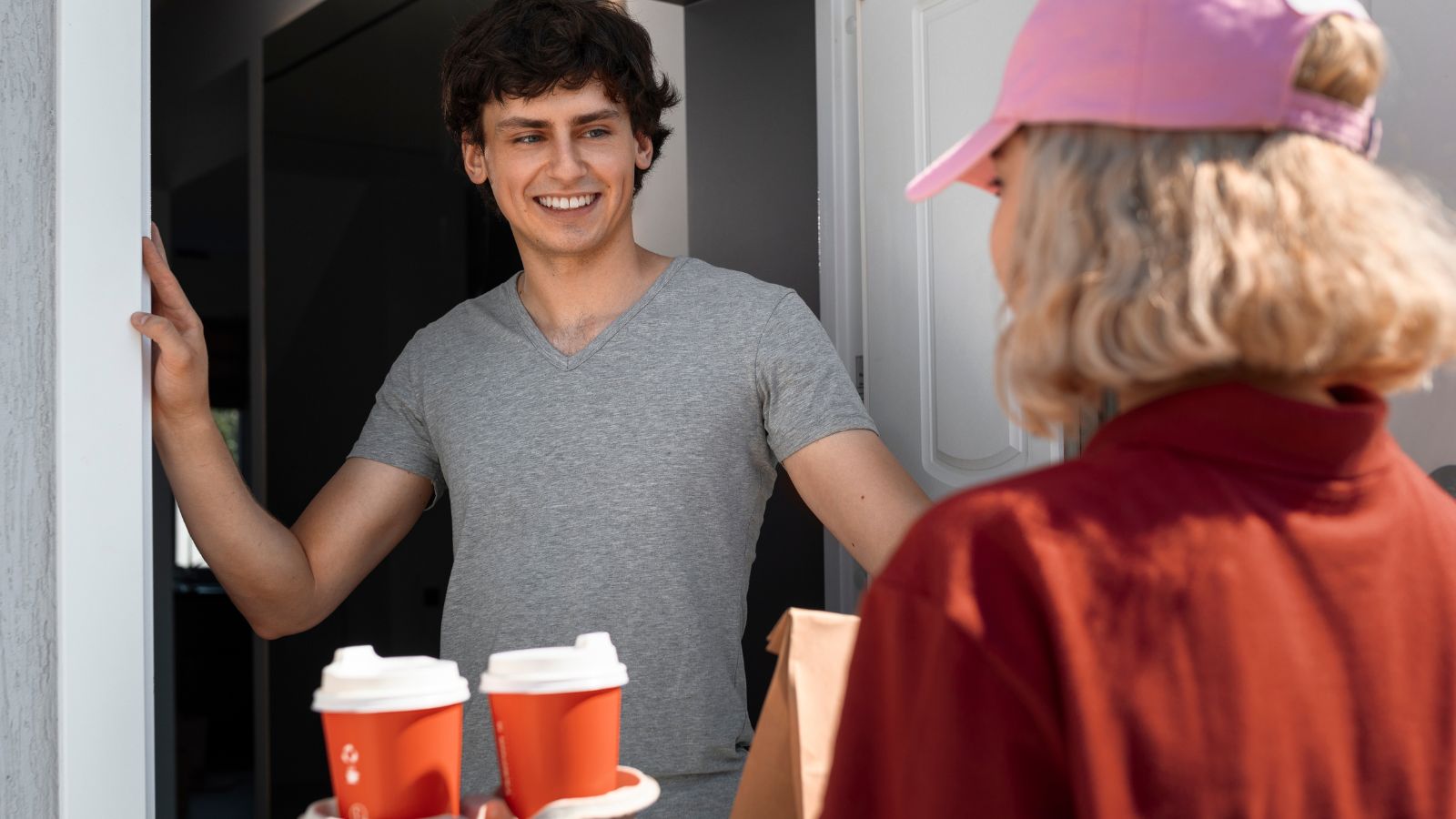 Jovem buscando delivery na porta