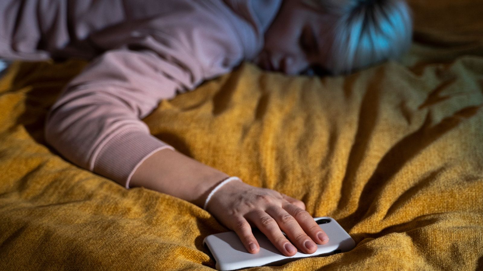 Mulher dormindo com celular na mão