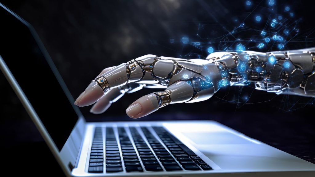 M&atilde;o de rob&ocirc; mexendo em notebook