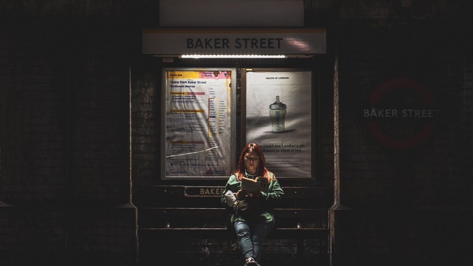 Mulher lendo livro em parada de ônibus