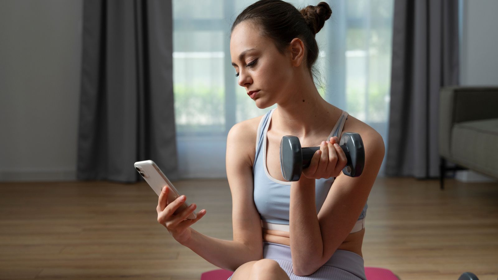 Mulher usando celular enquanto treina