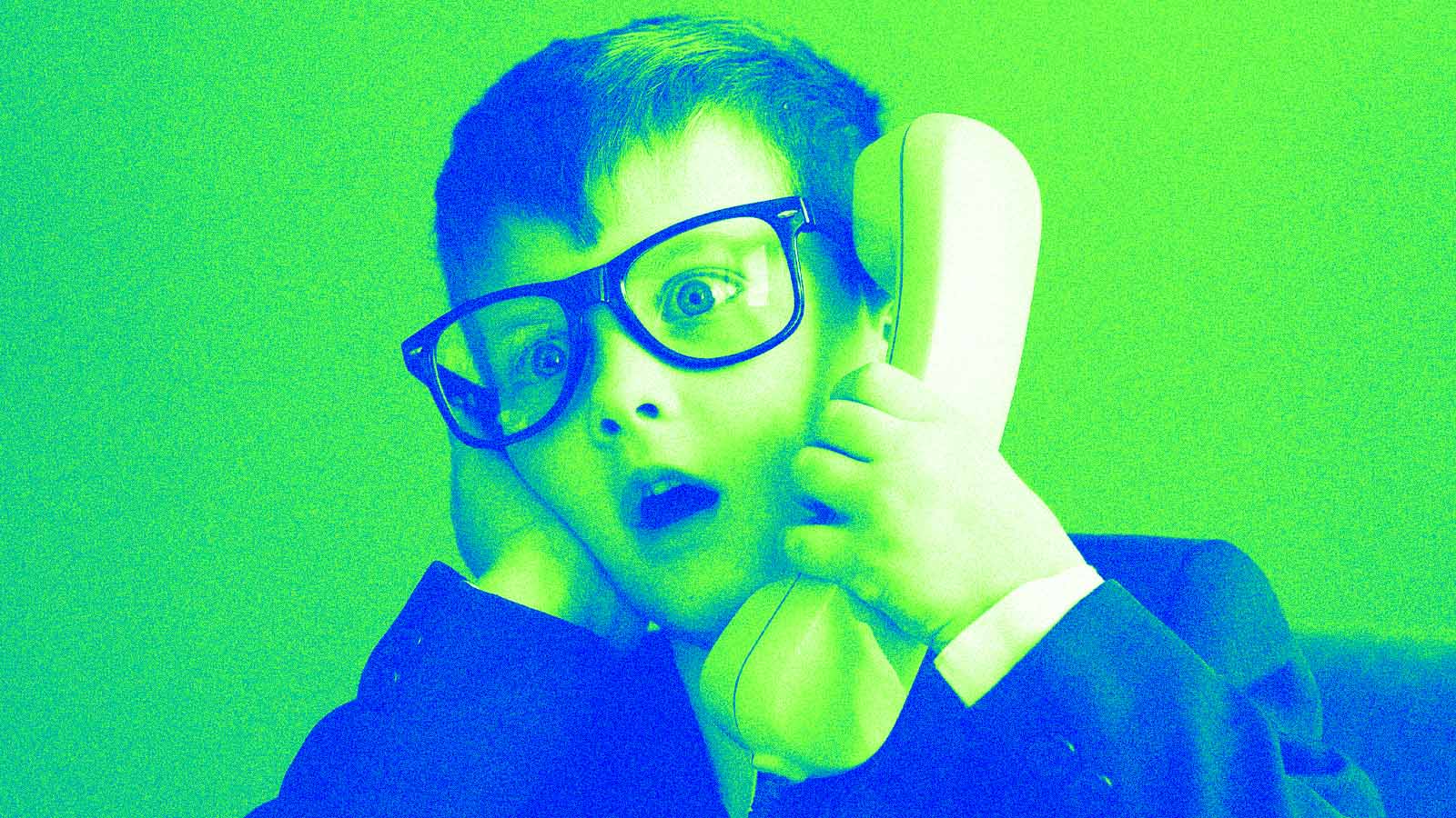 menino vestido de executivo atende o telefone