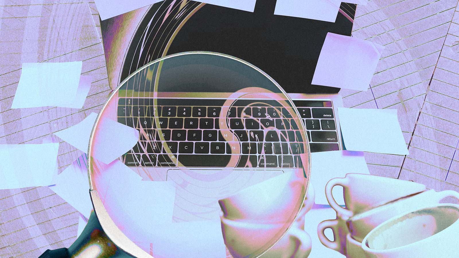 xícaras próximas a um teclado de computador