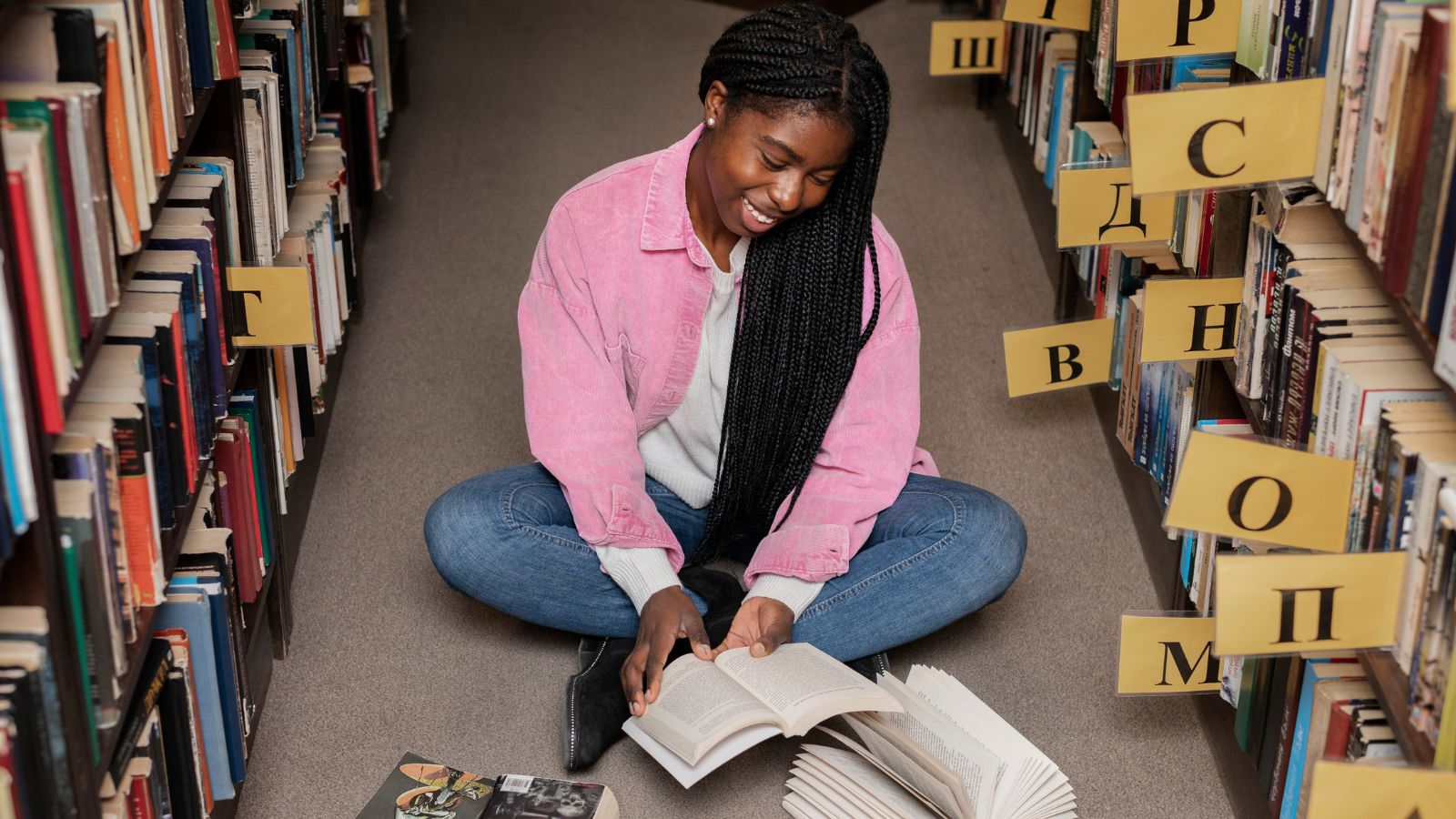 Jovem negra lendo livros em biblioteca