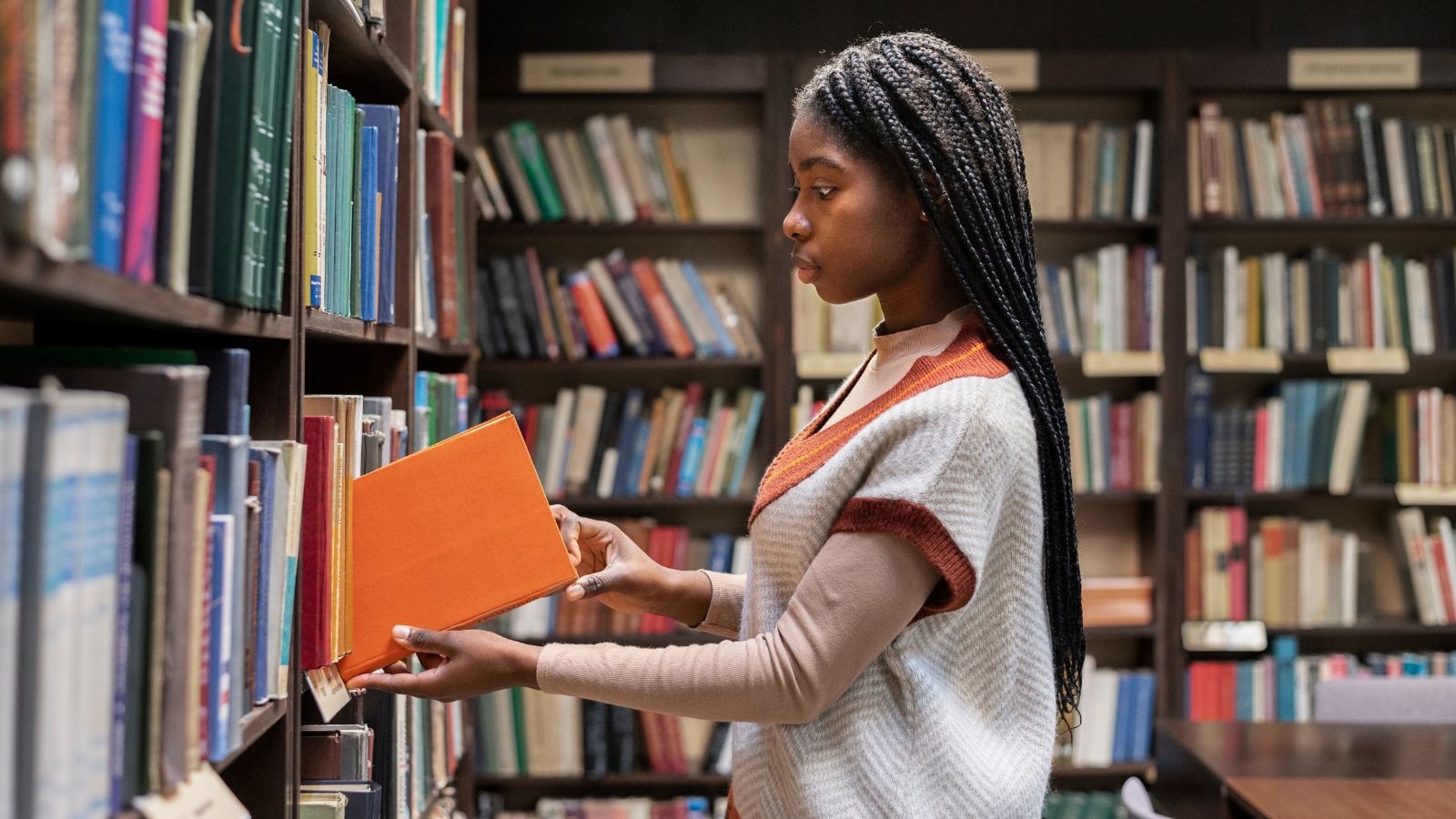 Mulher negra escolhendo livro