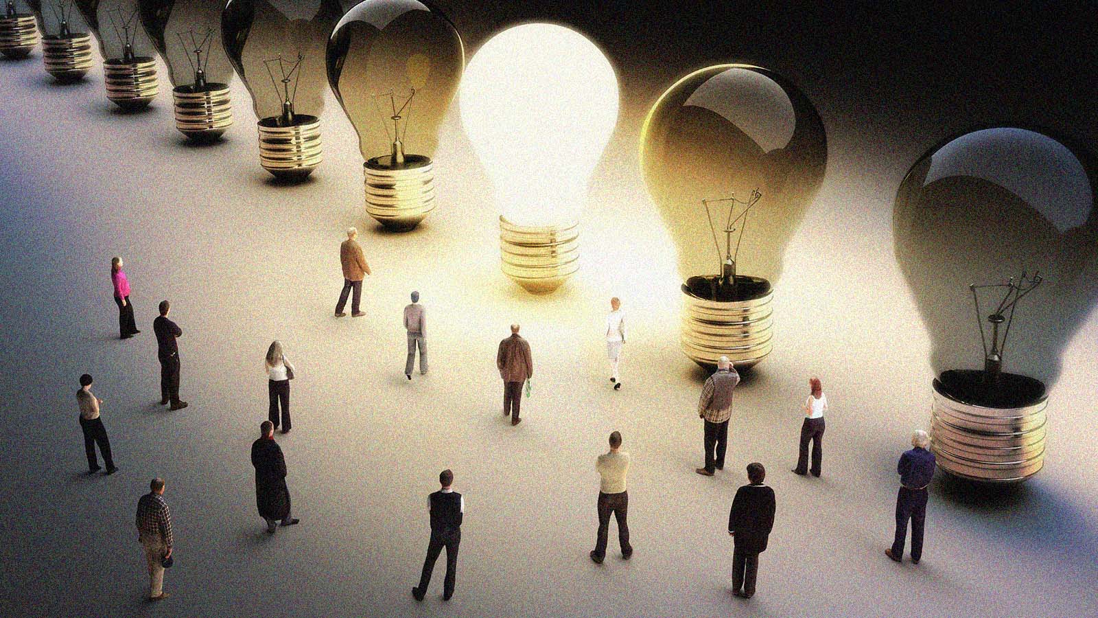 pessoas andam entre lâmpadas gigantes