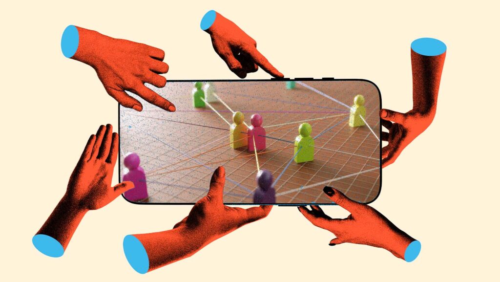 m&atilde;os seguram um celular com imagens de pinos representando pessoas