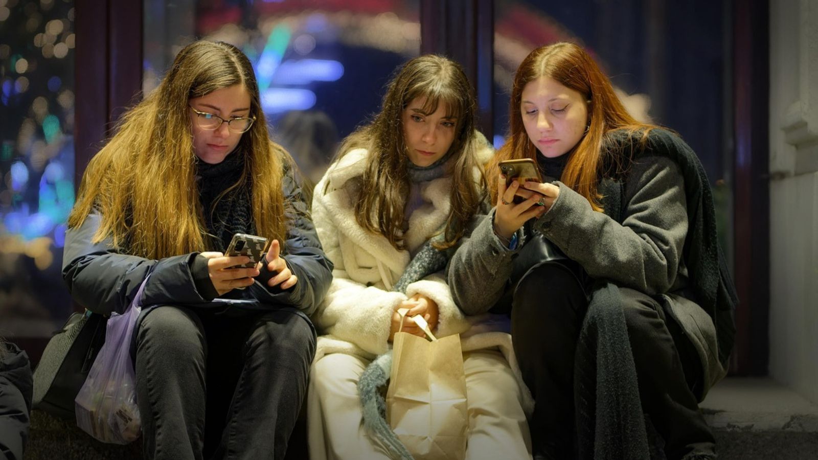 Amigas sentadas com celular