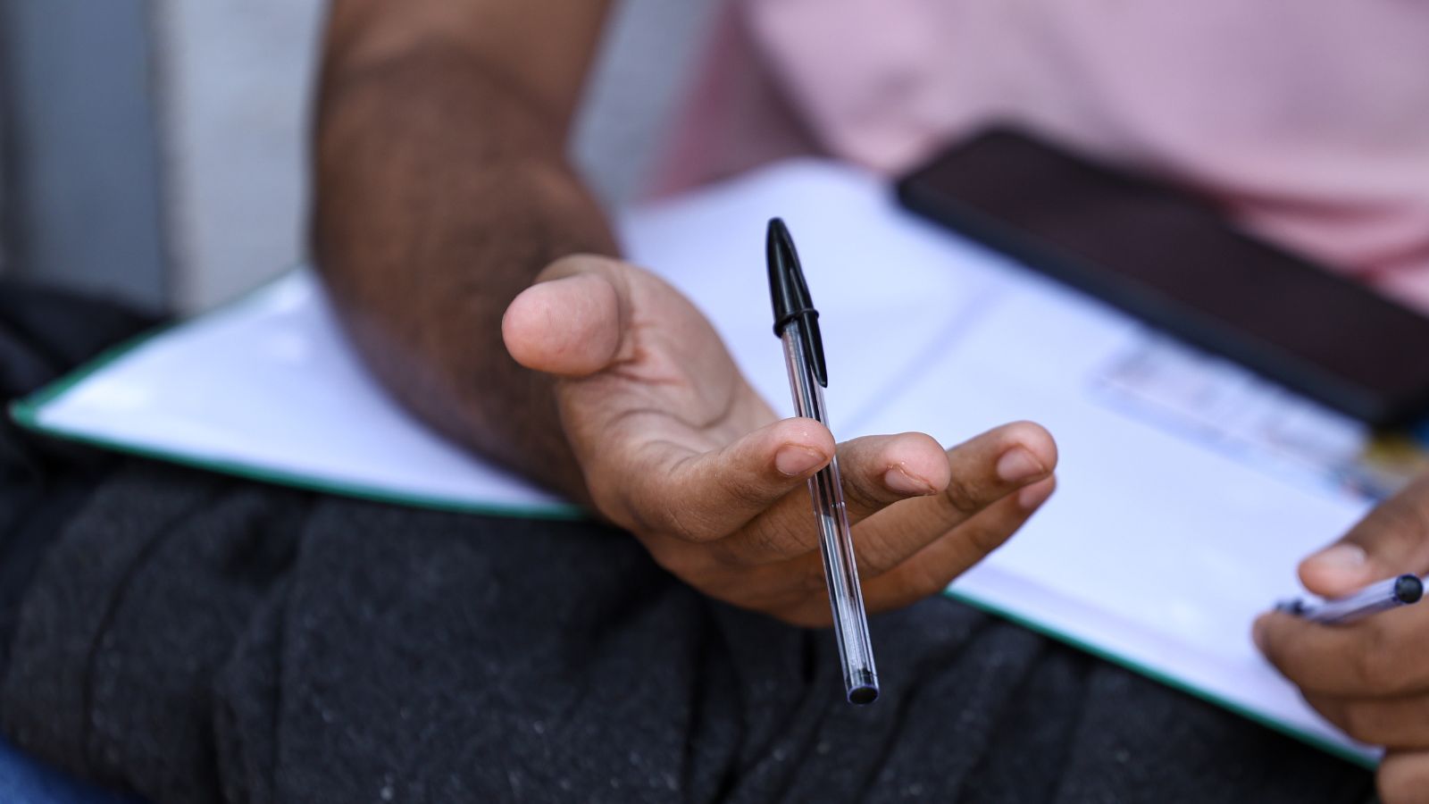Estudante com prova e caneta na mão
