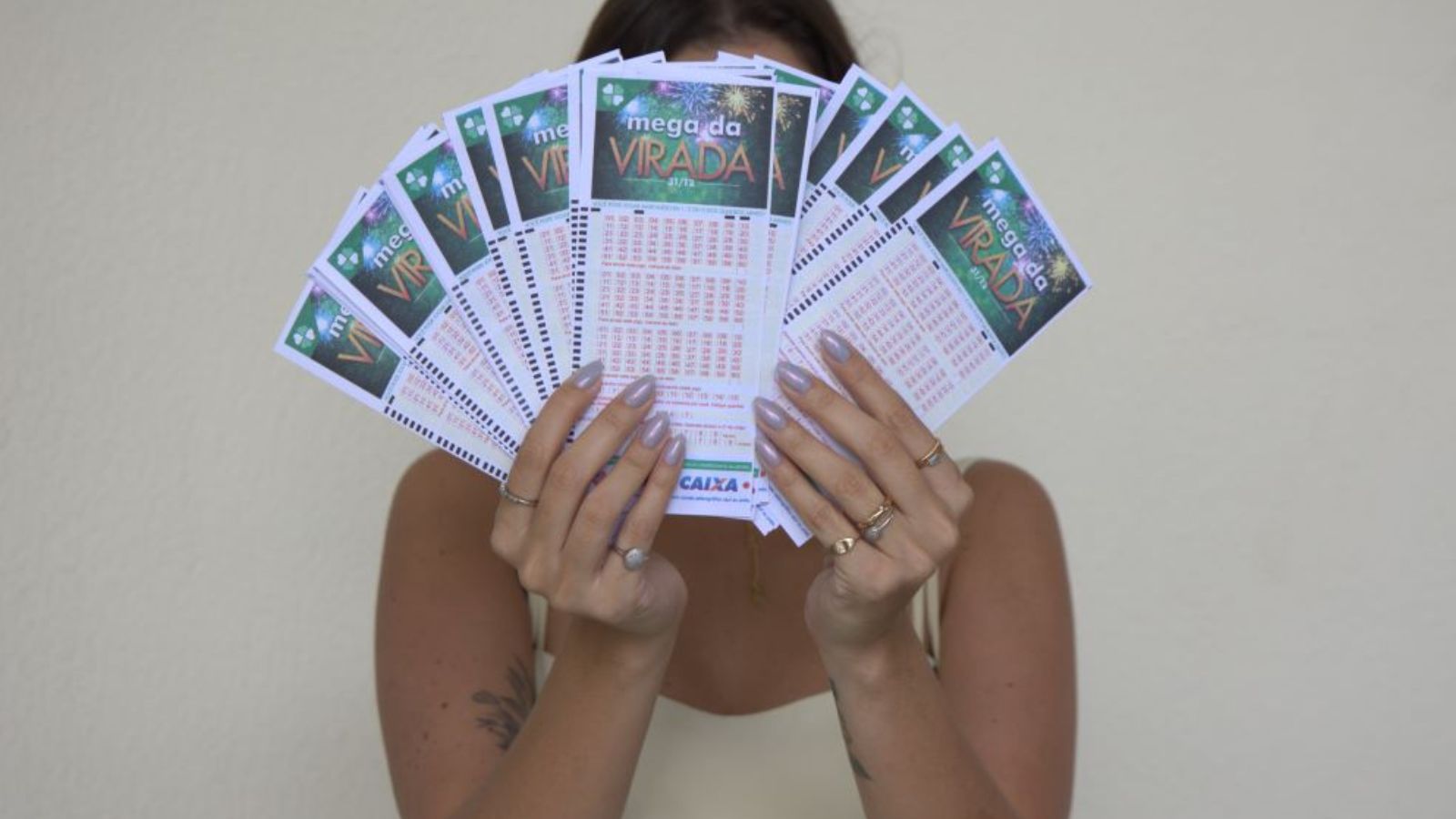 Mulher segurando bilhetes da Mega