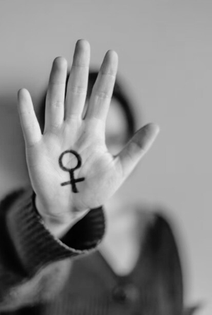 mulher com símbolo de feminino pintado na palma da mão