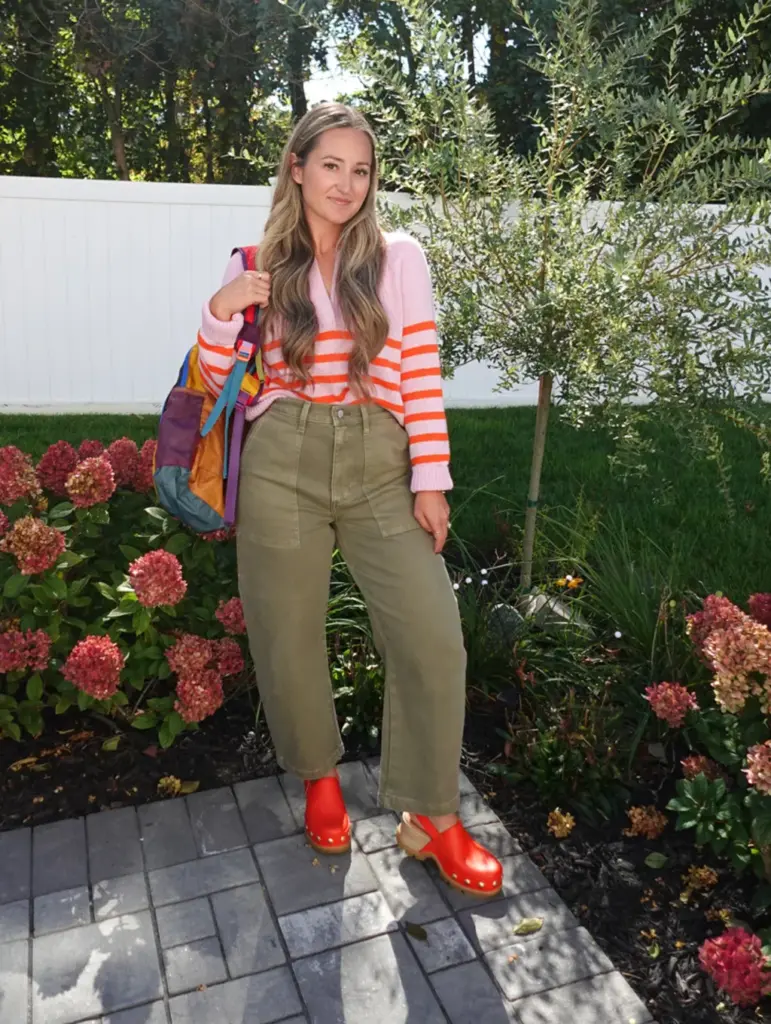 modelo exibe visual discreto com bolsa grande e sapatos na cor Chilli Red