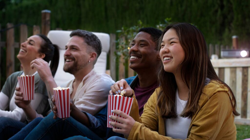 Amigos assistindo filmes no quintal