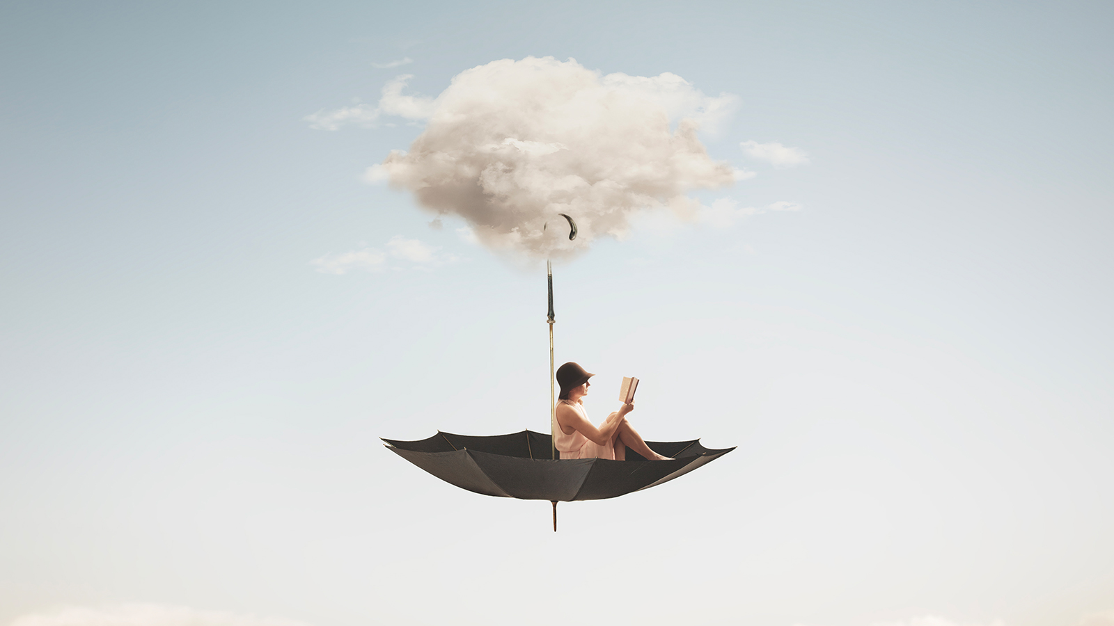 pessoa sentada em um guarda-chuva colocado de cabeça para baixo