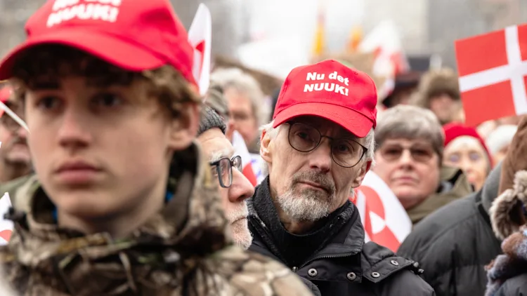 manifestantes protestam usando bon&eacute;s com mensagem  contra os EUA
