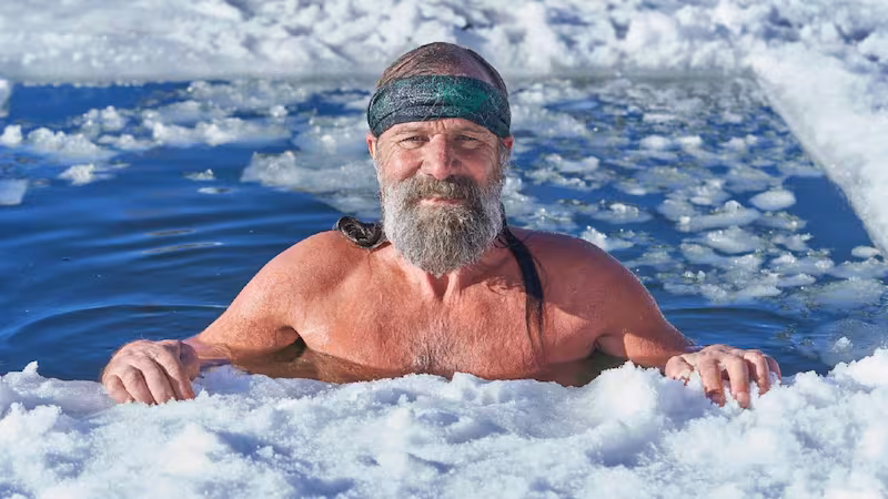 Wim Hof mergulhado em &aacute;gua gelada cercada por placas de gelo durante uma pr&aacute;tica de exposi&ccedil;&atilde;o controlada ao frio.