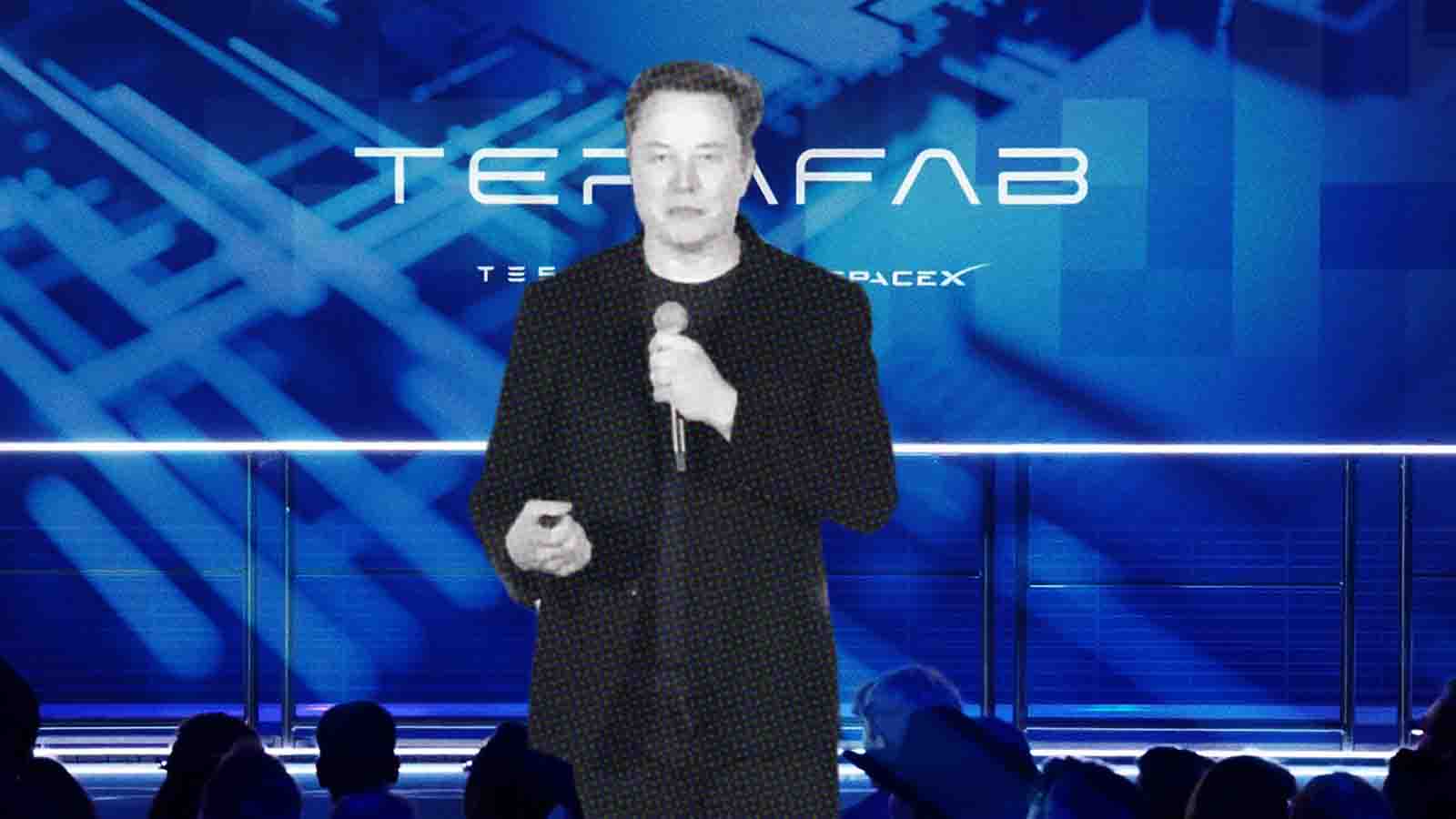 A imagem mostra Elon Musk em pé no centro de um palco, falando ao microfone durante uma apresentação. Ele veste um blazer preto texturizado sobre uma camiseta preta. Ao fundo, há um grande painel digital em tons de azul com design futurista, exibindo a palavra "TERAFAB" em letras grandes e brancas, acompanhada pelos logotipos da Tesla e da SpaceX em menor escala logo abaixo. Musk segura o microfone com a mão direita e gesticula levemente com a esquerda. Na parte inferior da foto, é possível ver a silhueta da plateia de costas, sugerindo o ambiente de uma conferência ou evento de tecnologia.