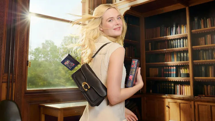 Elle Fanning mostra livros em formato de chaveiro da Penguin Random House/ Coach