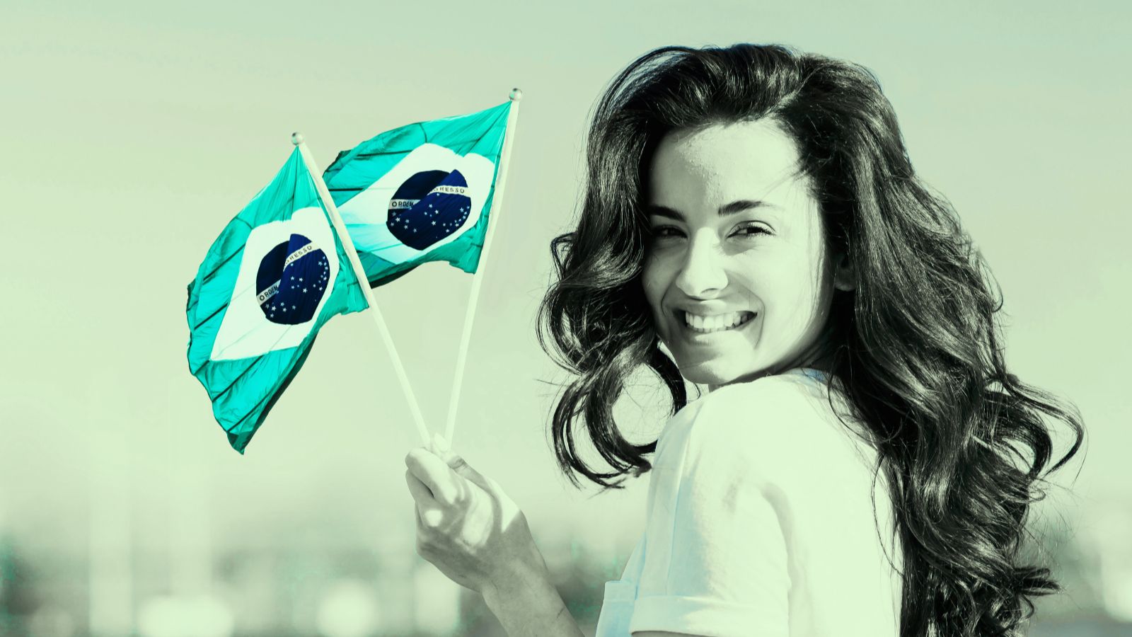 Mulher sorrindo segurando duas bandeirad o Brasil