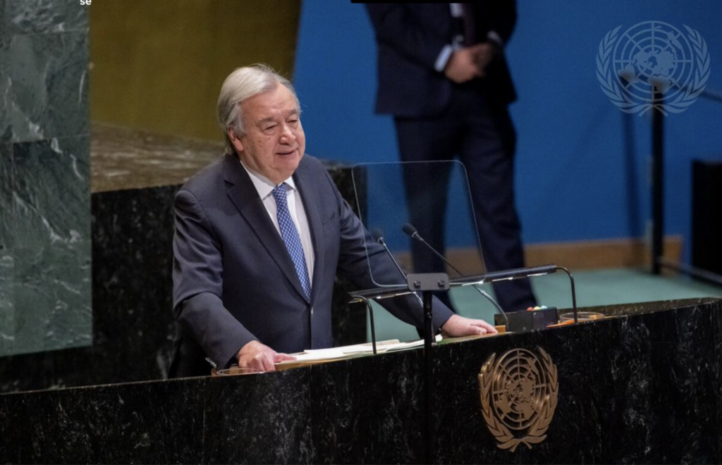 Homem de terno, Ant&oacute;nio Guterres, secret&aacute;rio-geral da ONU, fala em um p&uacute;lpito na Assembleia Geral da ONU, com o emblema das Na&ccedil;&otilde;es Unidas vis&iacute;vel no painel e ao fundo. A cena mostra um discurso oficial em ambiente diplom&aacute;tico.