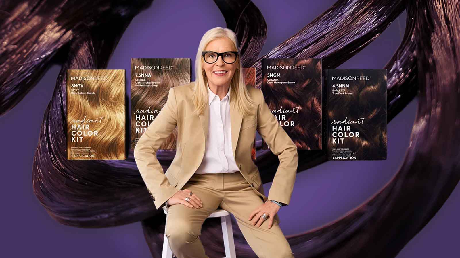 Uma executiva posa ao centro cercada por caixas de tintura capilar da marca Madison Reed, com mechas de cabelo estilizadas ao fundo. A imagem comunica empreendedorismo, liderança feminina, expansão de marca de beleza e mercado de coloração doméstica premium.