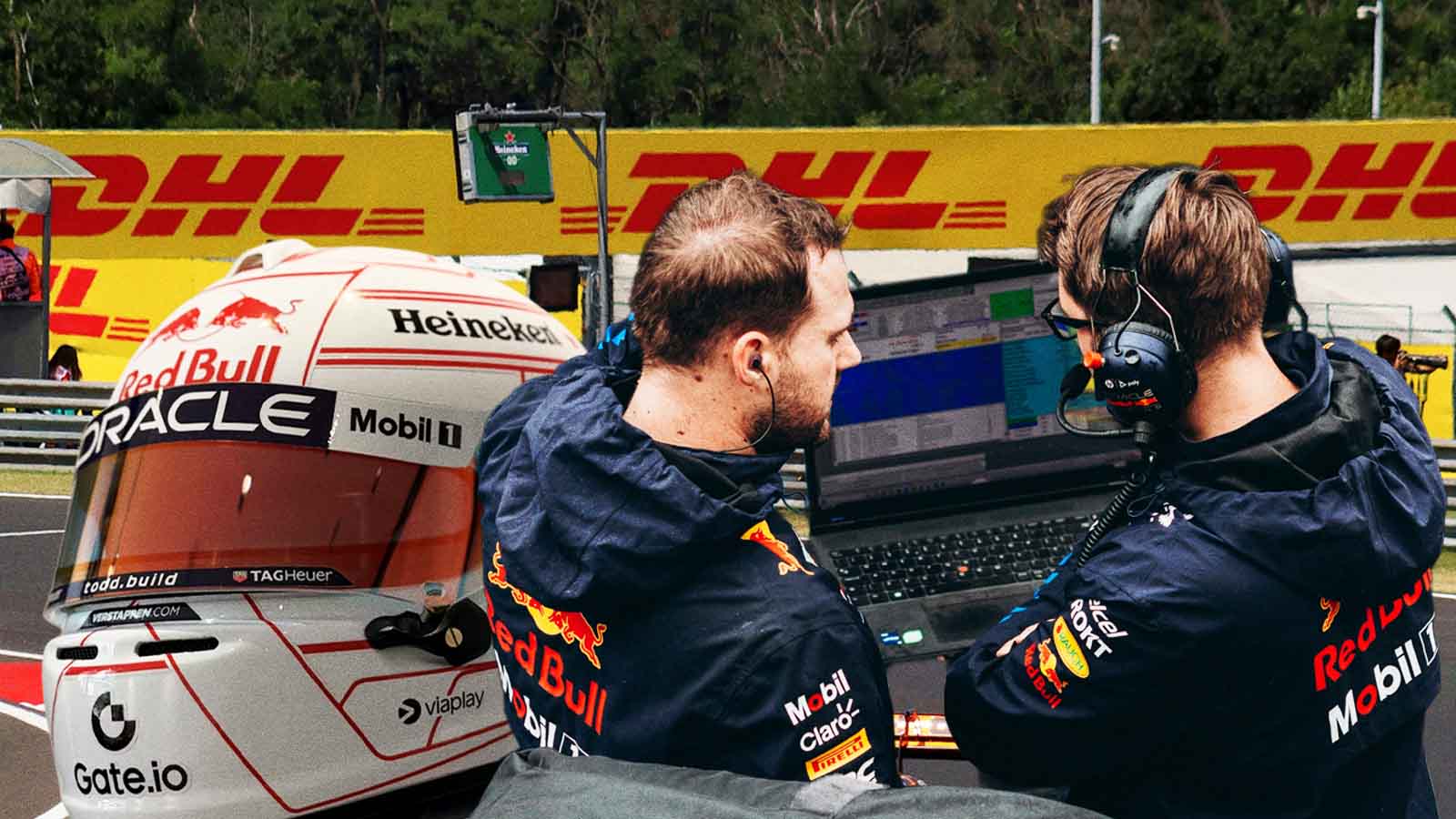 Dois integrantes da equipe Red Bull analisam dados em um laptop à beira da pista, ao lado de um capacete de piloto cercado por patrocinadores. A imagem remete à Fórmula 1, uso intensivo de tecnologia, estratégia em tempo real e bastidores de alta performance esportiva.