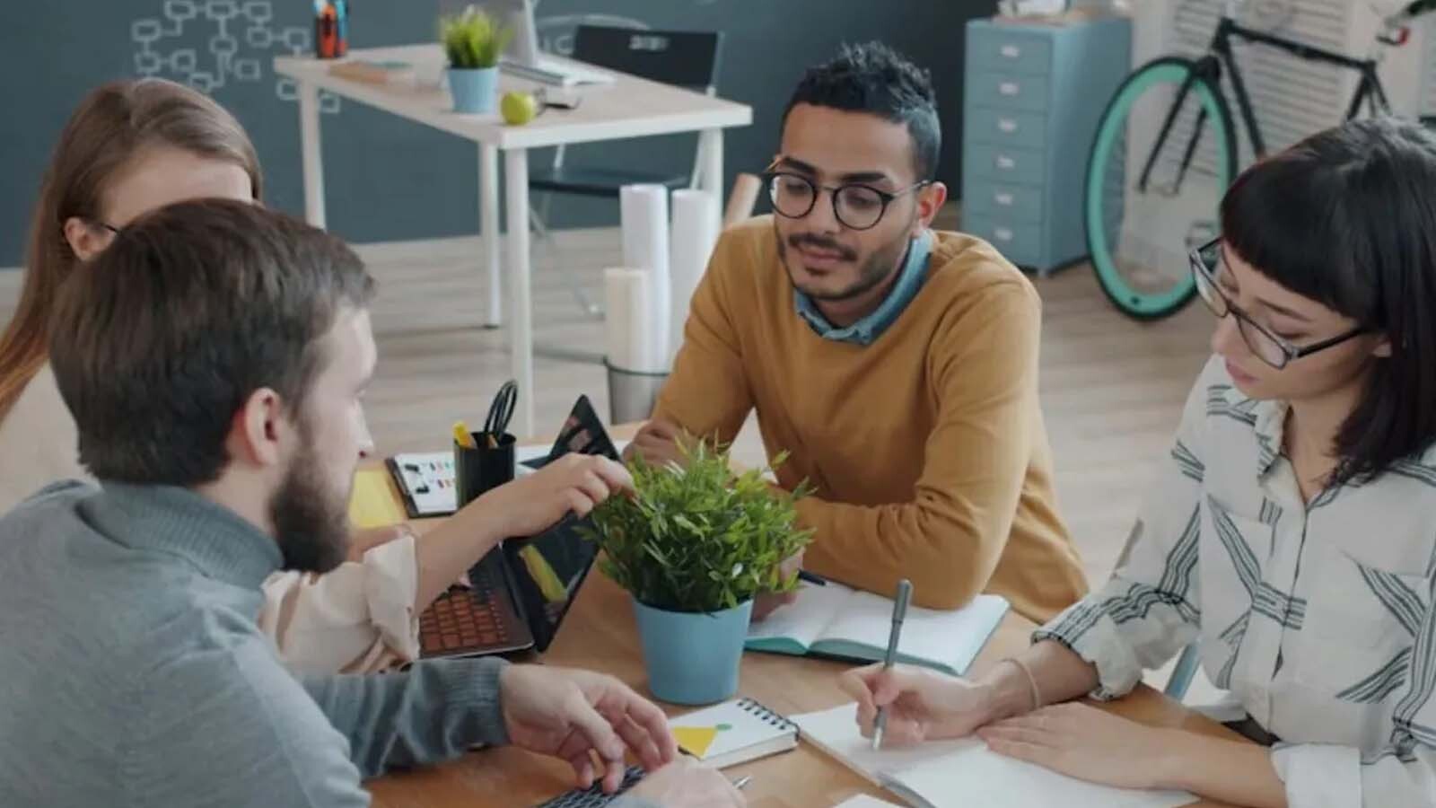 Quatro pessoas conversando em ambiente de trabalho