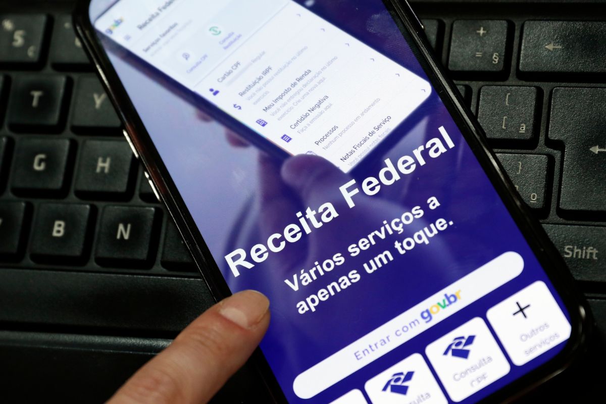 Pessoa utilizando o aplicativo da Receita Federal do Brasil, para consultar o Imposto de Renda.