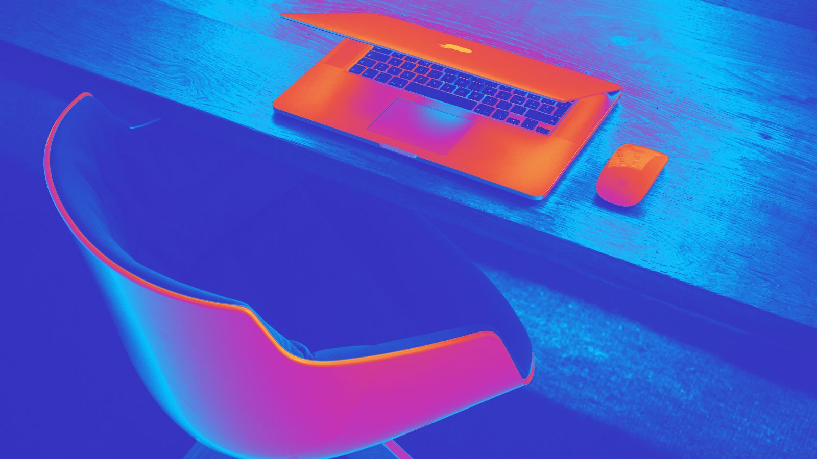 Na mesa há um laptop e uma cadeira.
