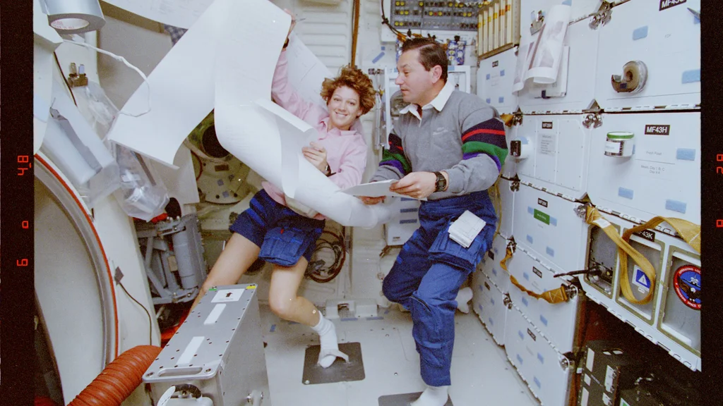 Eileen Collins e no ônibus espacial Discovery durante a missão STS