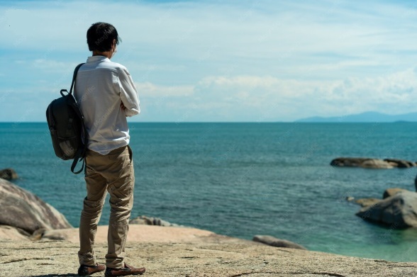 jovem com mochila nas costas olha para o mar