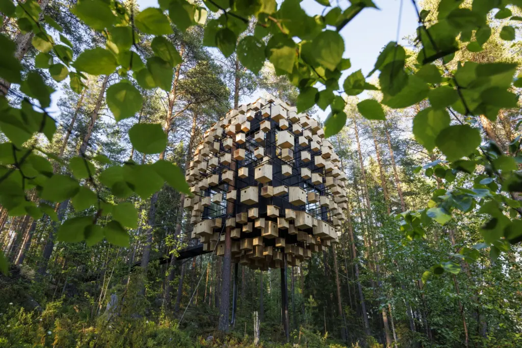 Estrutura arquitet&ocirc;nica Biosphere by BIG cercada por &aacute;rvores em uma floresta.
