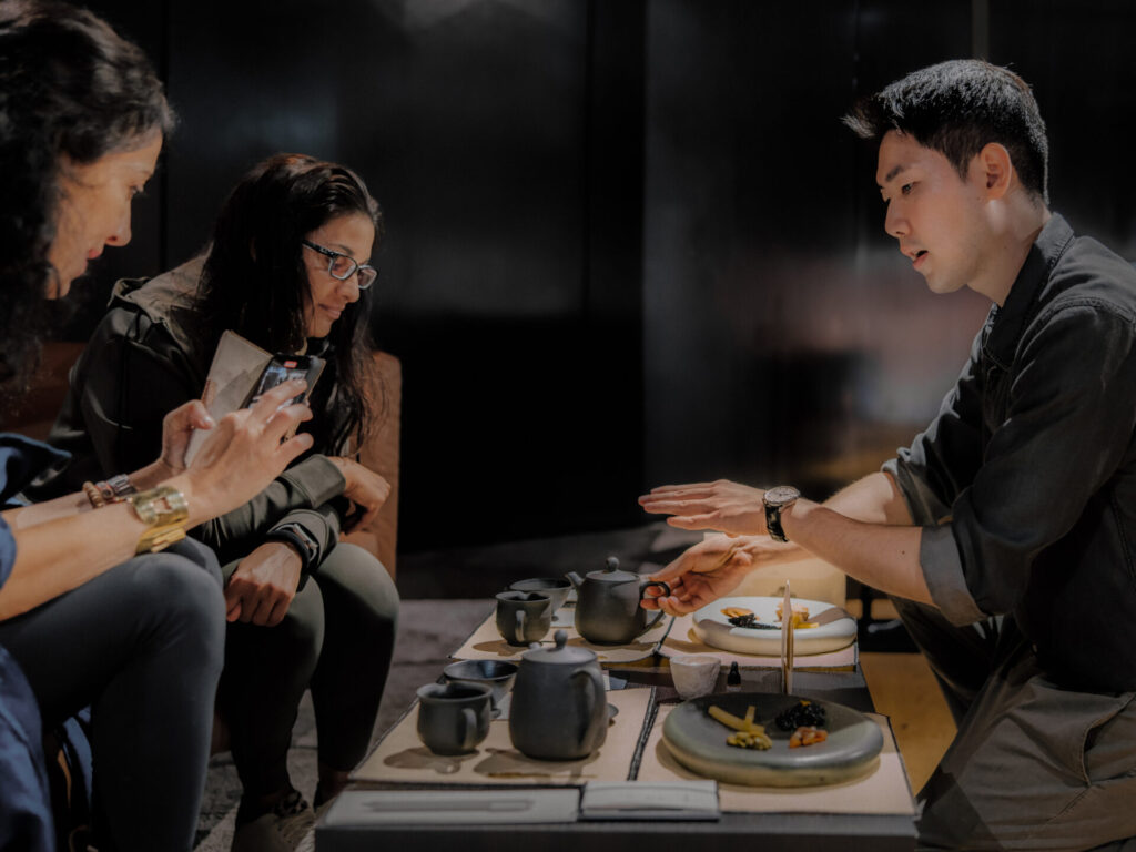 Pessoas participam de uma experi&ecirc;ncia de ch&aacute; coreano em um ambiente de showroom da Genesis.