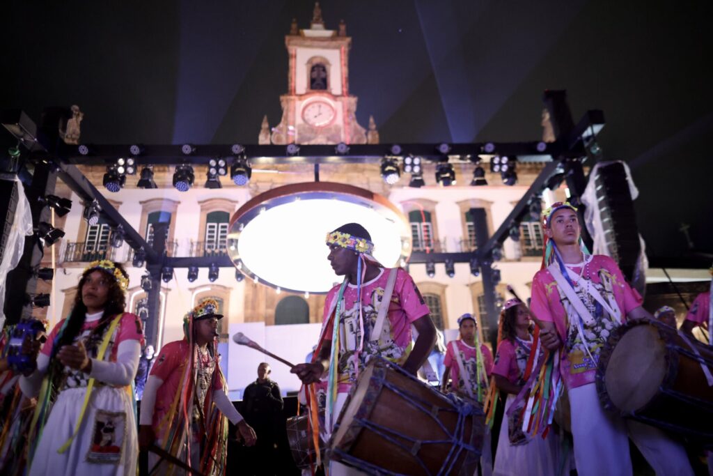 Integrantes da Guarda do Congo tocam tambores diante de uma igreja em Ouro Preto durante o Festival MARTE.