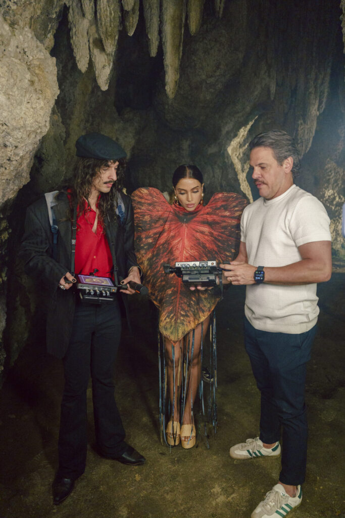 Anitta observa equipamentos de filmagem com dois integrantes da equipe em uma loca&ccedil;&atilde;o rochosa. Foto de Patrick Marinho