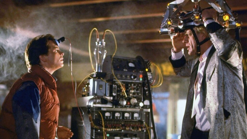 Marty McFly conversa com o cientista Doc Brown, que usa um aparelho na cabe&ccedil;a.