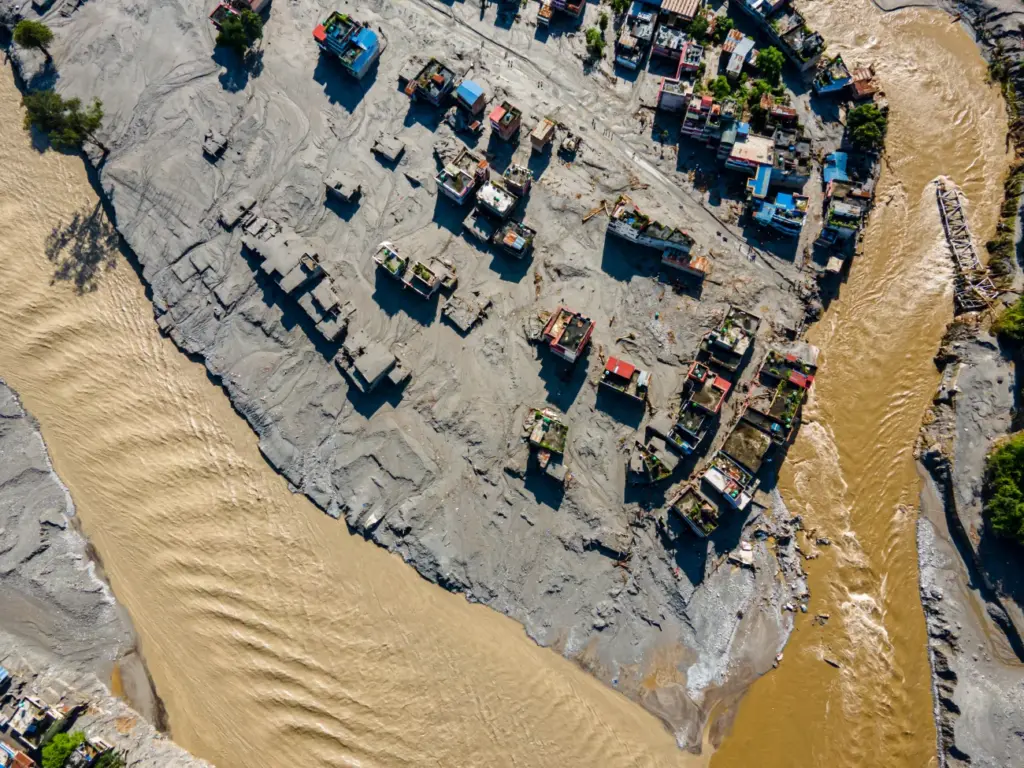 Vista a&eacute;rea de casas cobertas por lama e detritos ap&oacute;s inunda&ccedil;&atilde;o em Devghat, no Nepal.