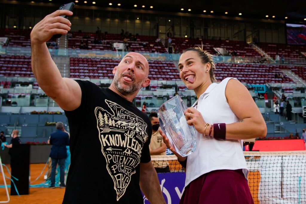 Aryna Sabalenka posa ao lado de seu preparador f&iacute;sico, Jason Stacy, em uma quadra de t&ecirc;nis